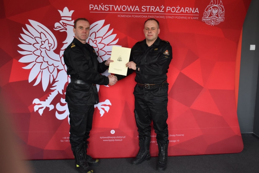 St. asp. Łukasz Linkner odbiera akt mianowania na wyższe stanowisko służbowe z rąk brygadiera Piotra Wlazłowskiego - komendanta powiatowego PSP w Iławie.