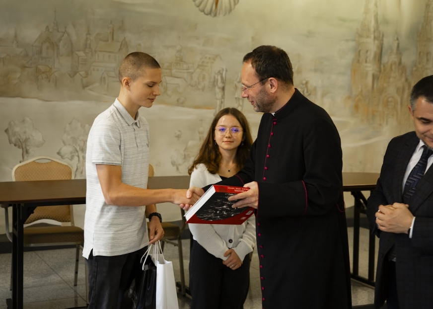 Natan odbiera gratulacje i nagrodę.