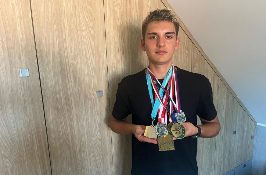 Wioślarz Oskar Fryc (Wir Iława) z medalami zdobytymi w ostatnich dwóch sezonach