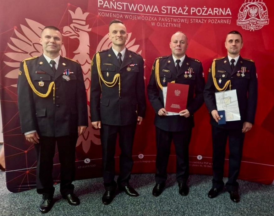 Komendant Powiatowy PSP w Iławie bryg. Marcin Wiśniewski i odznaczeni strażacy z iławskiej komendy.
