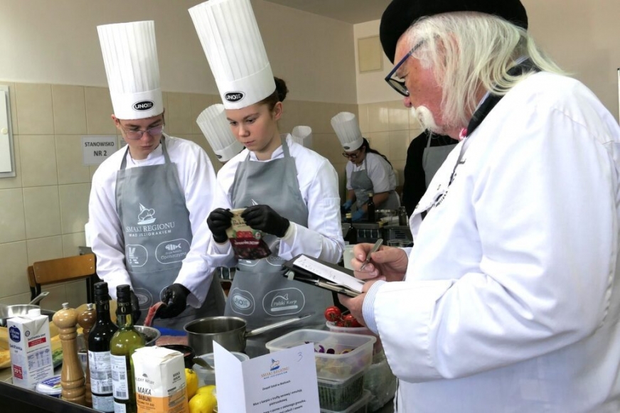 Zdjęcie z ubiegłorocznych zmagań młodych kucharzy w Zespole Szkół im. Konstytucji 3 Maja w Iławie pod okiem samego Kurta Schellera, szwajcarskiego szefa kuchni, jurora w konkursie kulinarnym „Smaki Regionu nad Jeziorakiem”.