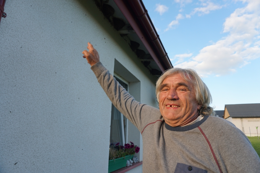 Andrzej Kumiński prezentuje okap dachu swojego domu w Nowej Wsi, pod którym - łącznie - jest aż 50 jaskółczych gniazd.